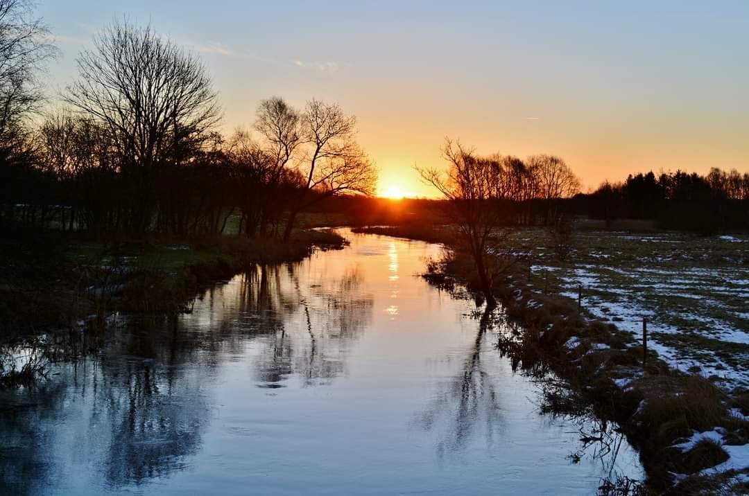 Solnedgang over å. Vinter.