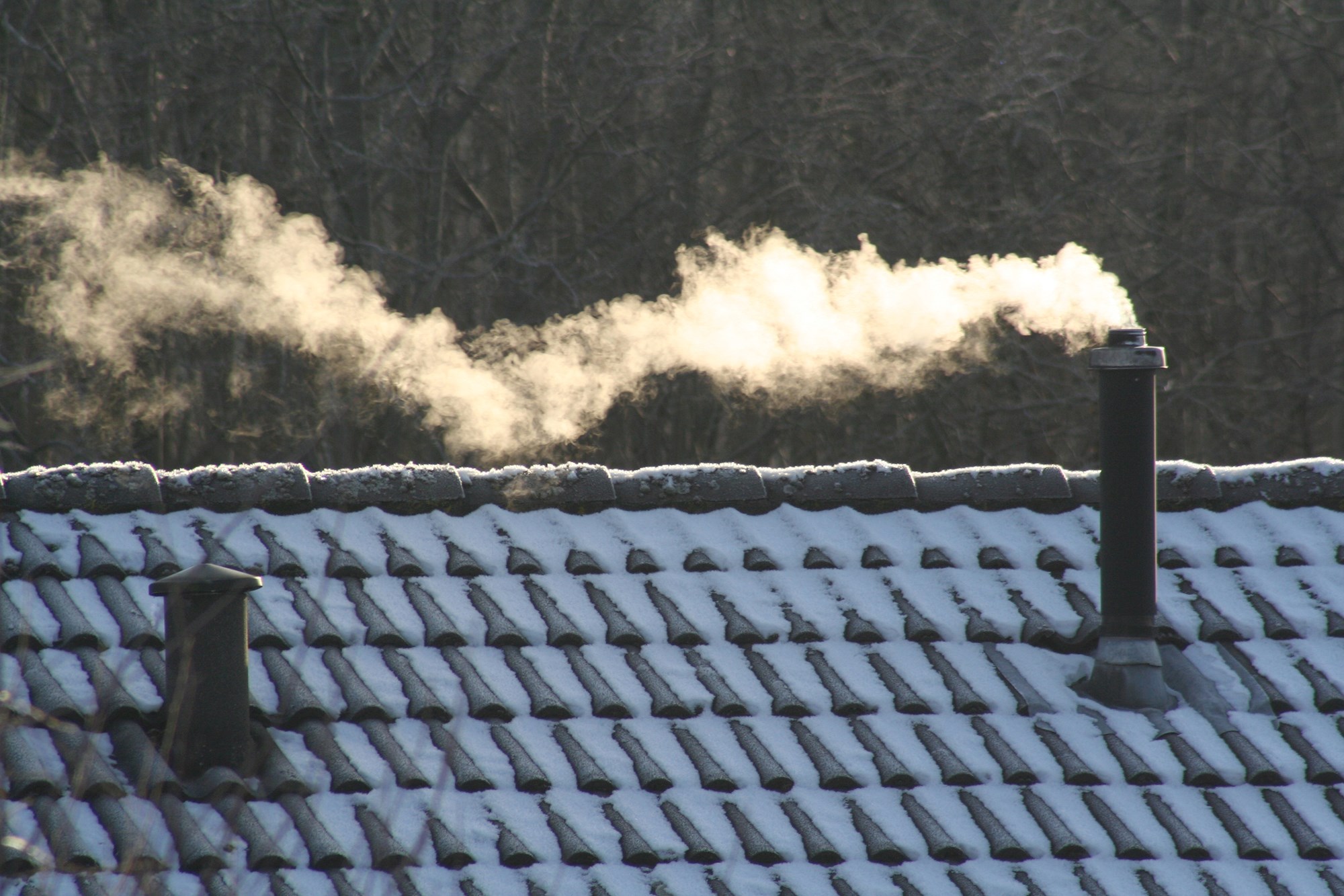 Skorsten damper på et teglgtag på en kold vinterdag