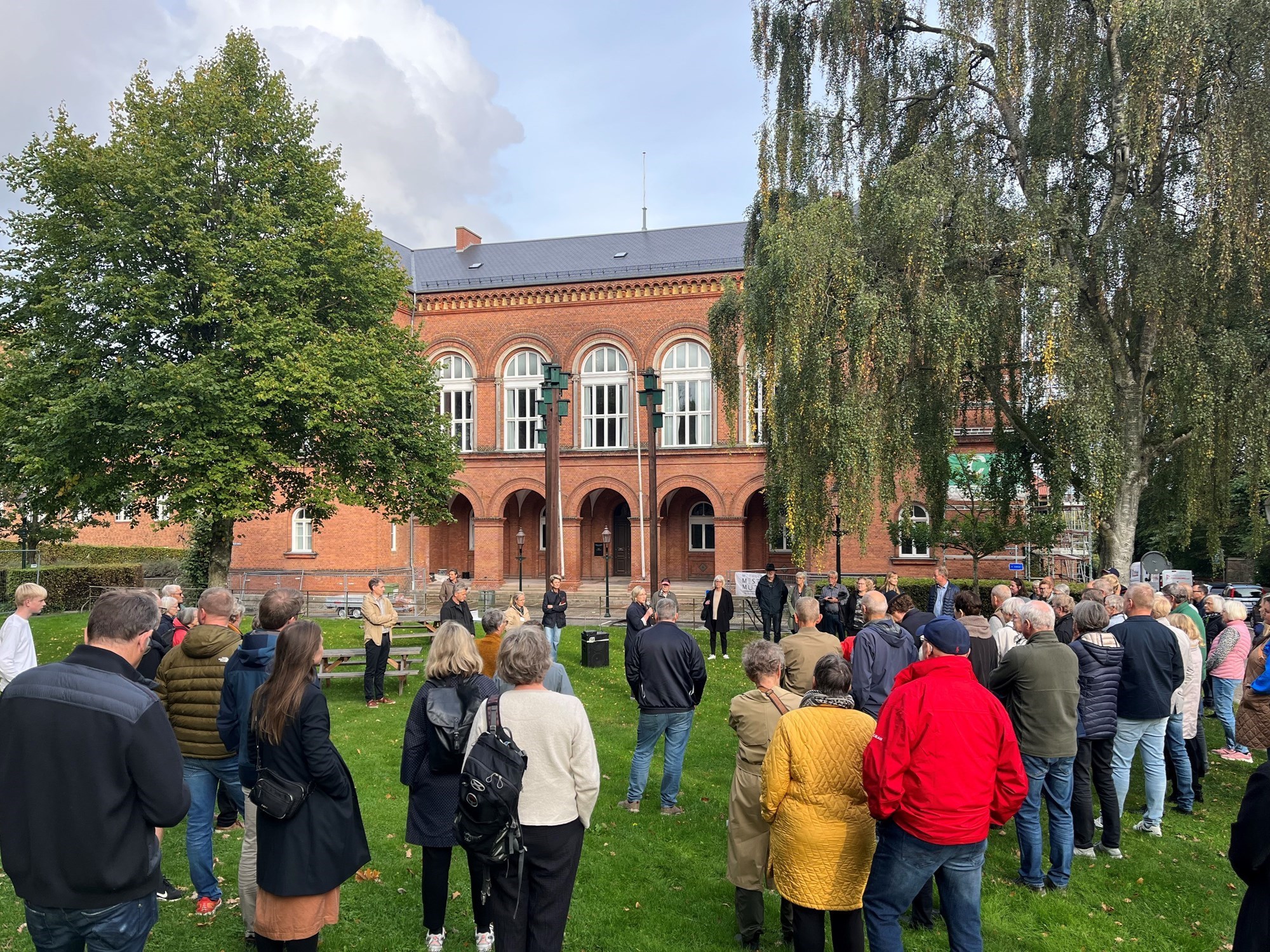 Mange mennesker på græsset foran det gamle Rådhus